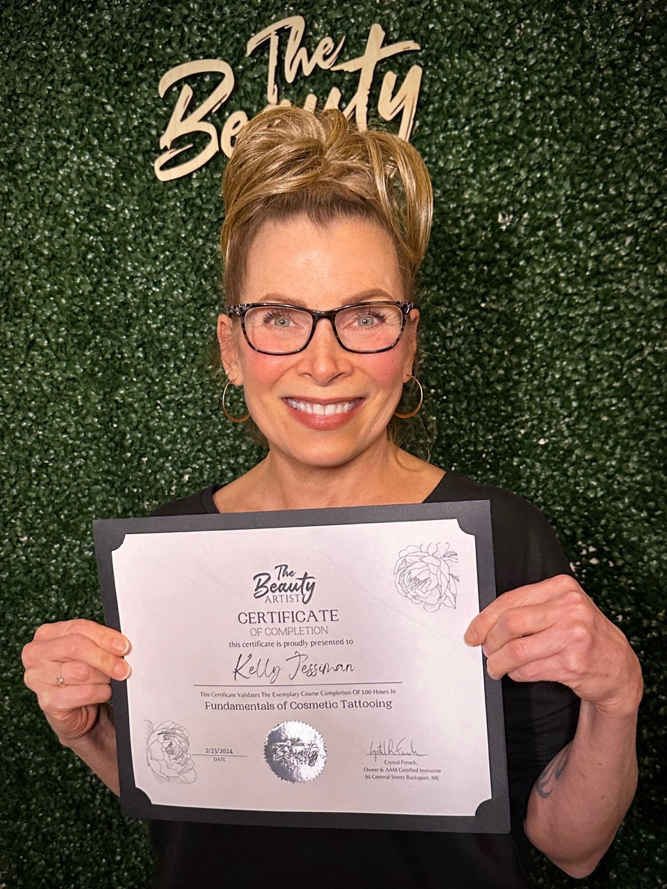 Photo of Kelly Jessiman holding course completion certificate